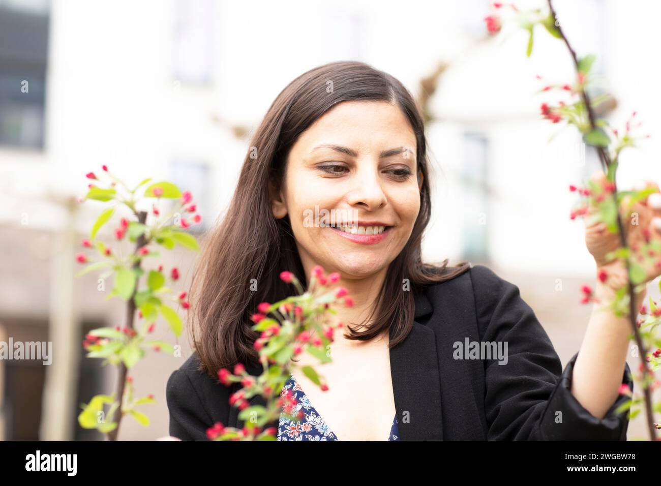 Femme souriante debout dans son jardin s'occupant de ses plantes, Allemagne Banque D'Images