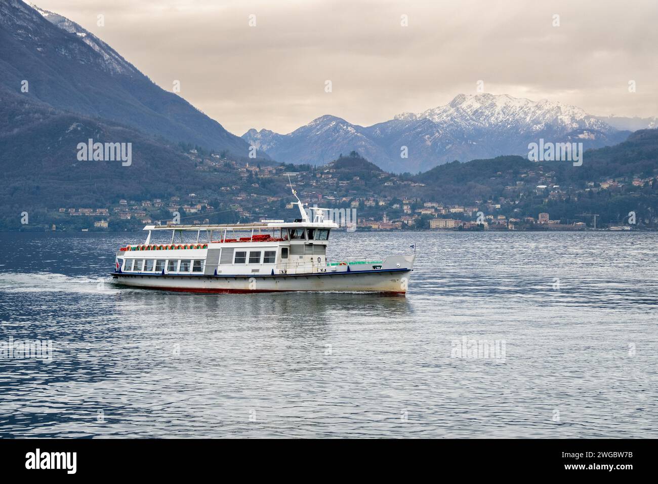 Ferry bateau naviguant à travers le lac de Côme avec toile de fond de montagne, Varenna, Lombardie, Italie Banque D'Images