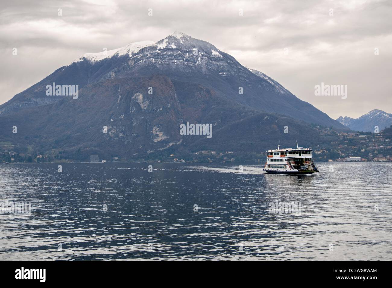 Ferry bateau naviguant à travers le lac de Côme avec toile de fond de montagne, Varenna, Lombardie, Italie Banque D'Images