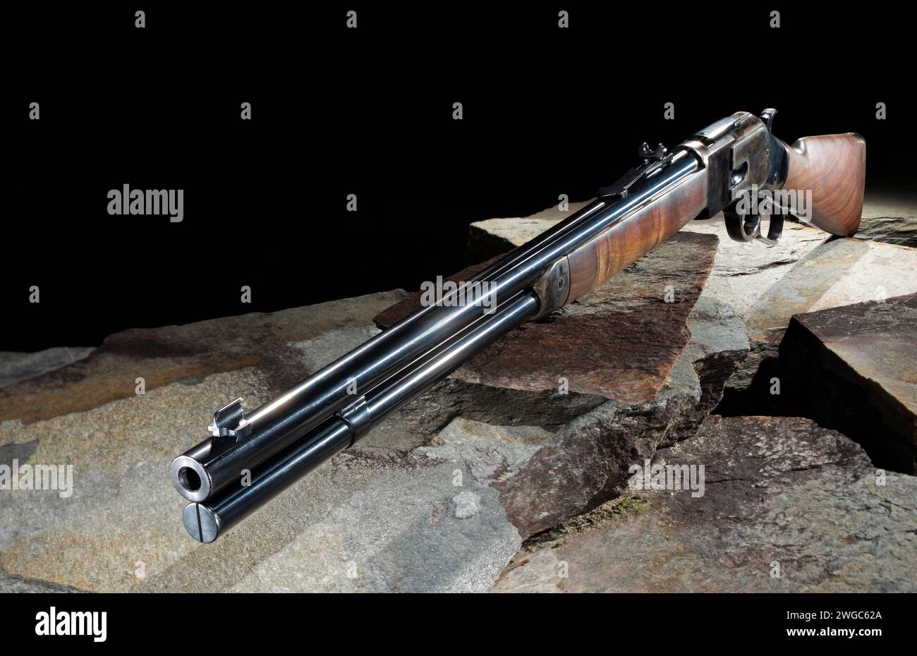 Fusil à levier répété comme le genre utilisé dans l'ouest sauvage sur les pierres qui montrent le stock de bois huilé et bleuissement profond sur la métallurgie. Banque D'Images