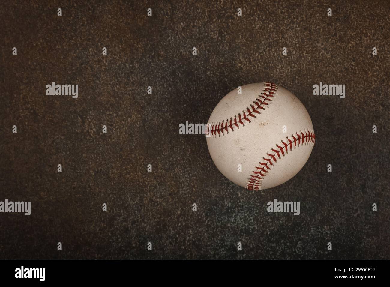 Gros plan sur une vieille balle de baseball vintage avec couture rouge sur fond brun foncé grunge avec espace pour copier, vue surélevée, juste au-dessus Banque D'Images