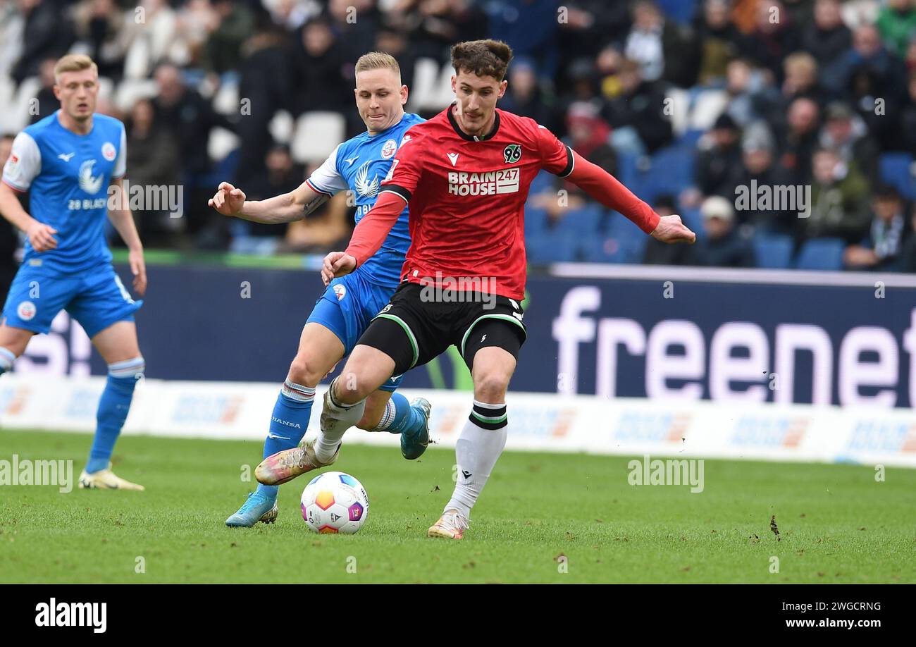 Hanovre, Allemagne. 04 février 2024. Football : Bundesliga 2, Hanovre 96 - Hansa Rostock, Journée 20, Heinz von Heiden-Arena : Kai Pröger de Rostock (l) combat pour le ballon contre Phil Neumann de Hanovre. Crédit : Carmen Jaspersen/dpa - NOTE IMPORTANTE: conformément aux règlements de la Ligue allemande de football DFL et de la Fédération allemande de football DFB, il est interdit d'utiliser ou de faire utiliser des photographies prises dans le stade et/ou du match sous forme d'images séquentielles et/ou de séries de photos de type vidéo./dpa/Alamy Live News Banque D'Images