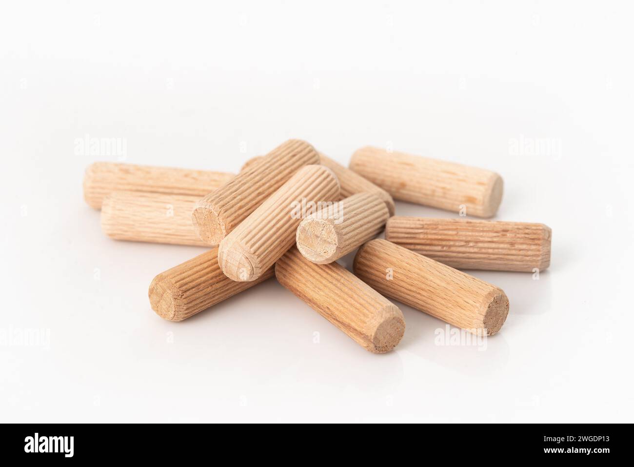 Pile de chevilles en bois isolées sur fond blanc. Banque D'Images