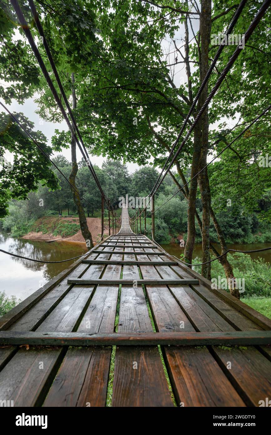 Pont singe suspendu sur la rivière Minija en Lituanie. Vue de face d'un pont de corde suspendu au-dessus d'une rivière. Photo verticale. Banque D'Images