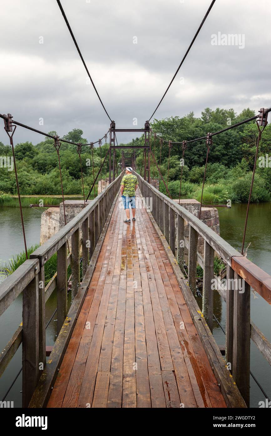 Pont piétonnier de structures métalliques complexes et lourdes. La pluie légère d'été et les touristes peuvent admirer la nature de la Lituanie. Photo verticale. Banque D'Images