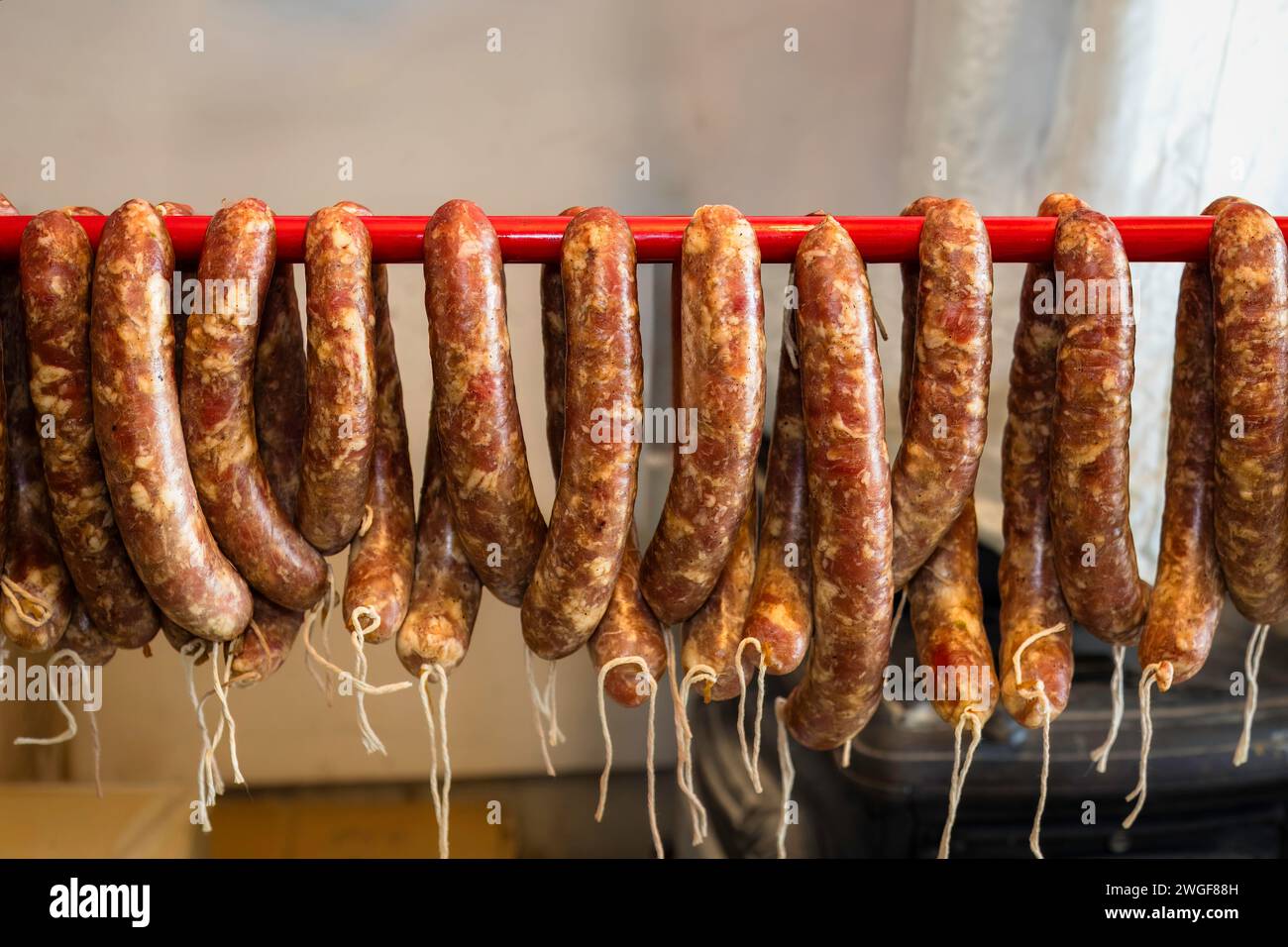 Nourriture traditionnelle. Saucisses crues suspendues et préparées pour être fumées dans un fumoir domestique. Banque D'Images