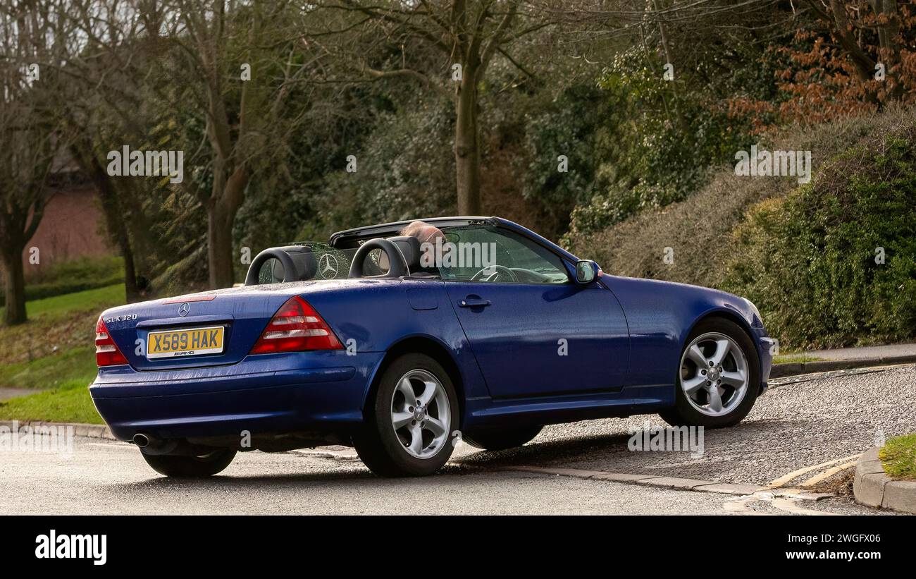 Milton Keynes, UK-Feb 4th 2024 : 2000 bleu Mercedes Benz SLK voiture classique à toit ouvert conduisant sur une route anglaise. Banque D'Images