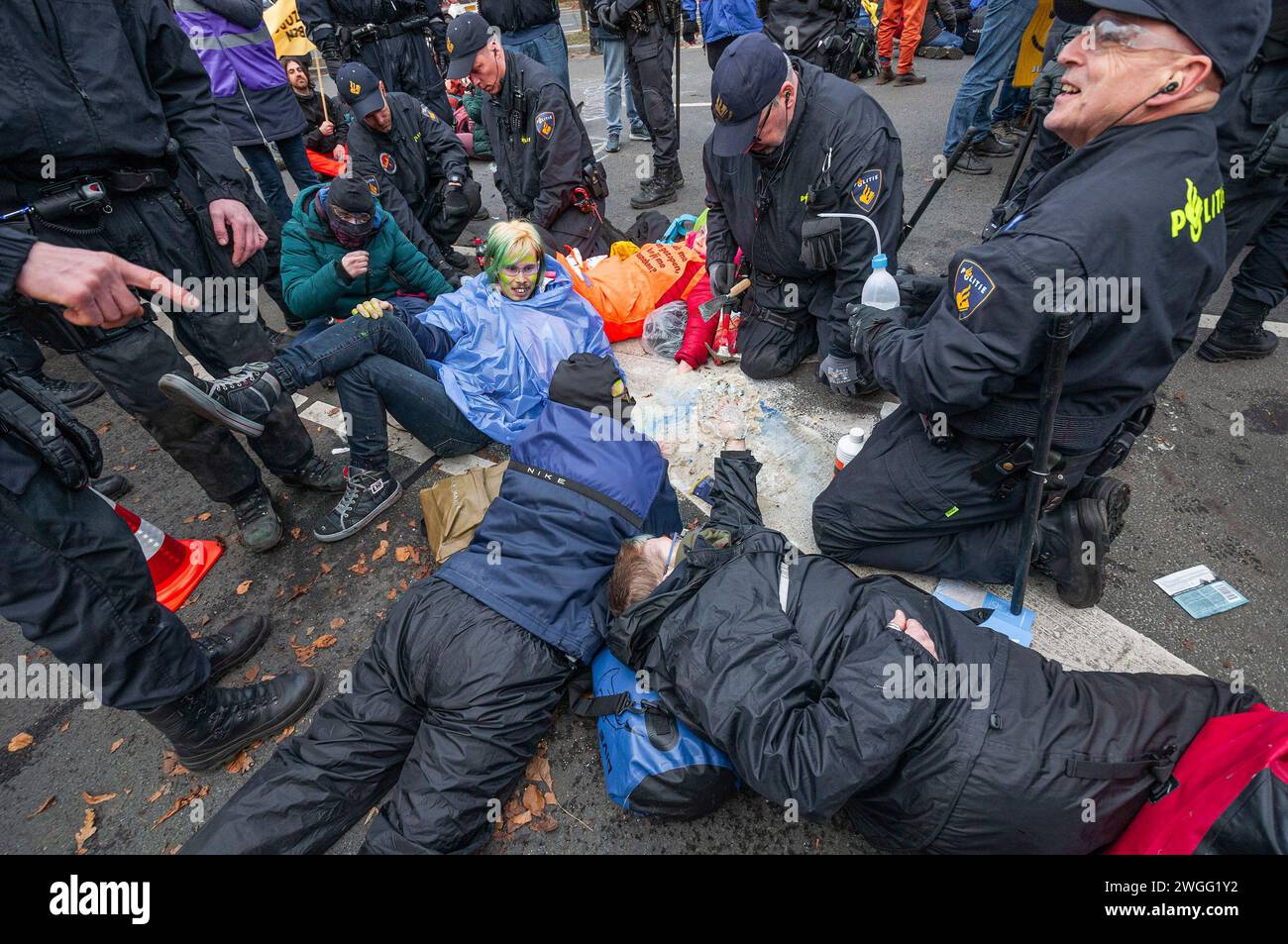 Extinction Rebellion activistes avec les mains incisées dans un mélange de super colle et de sable, attendent d'être enlevés pendant la manifestation. La police a expulsé 1 000 militants du climat de l’A12 à la Haye et les a transférés au stade de football ADO à la Haye, où ils ont été relâchés. L'autoroute a été bloquée dans les deux sens par des militants climatiques de extinction Rebellion à partir de 13 heures, bien que deux canons à eau étaient présents, ils n'ont pas été utilisés. C'était le premier blocus de l'A12 en quatre mois. L’année dernière, extinction Rebellion a bloqué l’A12 plusieurs dizaines de fois. Leurs actions l'étaient Banque D'Images