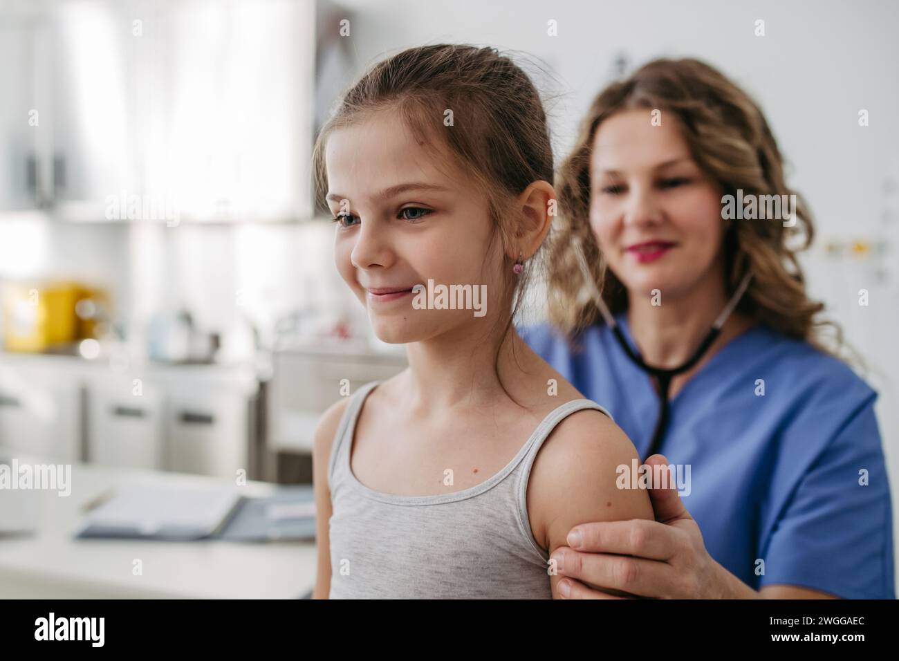 Orthopédiste examine la colonne vertébrale, la posture et les déformations spinales de la petite fille. Jeune fille en visite chez un pédiatre pour un examen préventif annuel. Concept de Banque D'Images