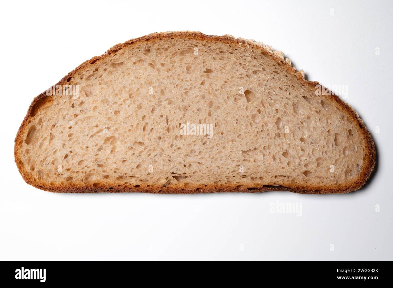 , Food, 04.02.2024, Das Bild zeigt eine einzelne Scheibe Brot auf einem weißen Hintergrund. Es handelt sich um eine Nahaufnahme, die die die Textur und P Banque D'Images