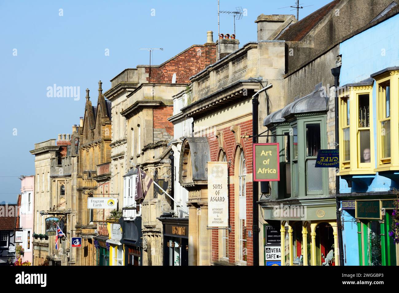 Magasins le long de High Street dans le centre-ville, Glastonbury, Somerset, Royaume-Uni, Europe. Banque D'Images