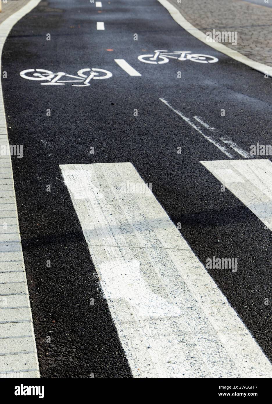 Du haut de la route asphaltée vide avec des lignes de démarcation blanches et des piétons zèbre traversant des marques tandis que des impressions d'image de vélo peintes sur noir Banque D'Images