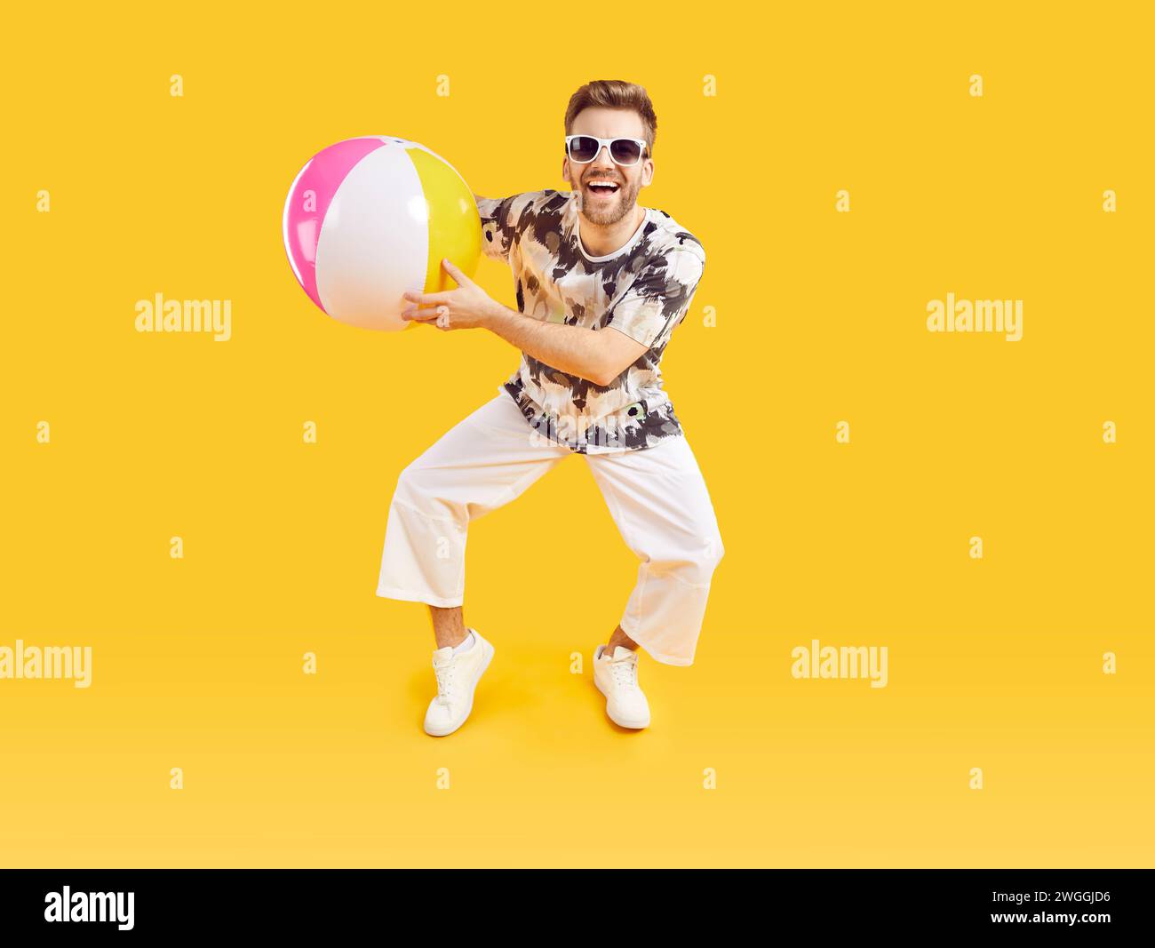 Heureux homme excité dans des lunettes de soleil tenant ballon de mer gonflable Banque D'Images