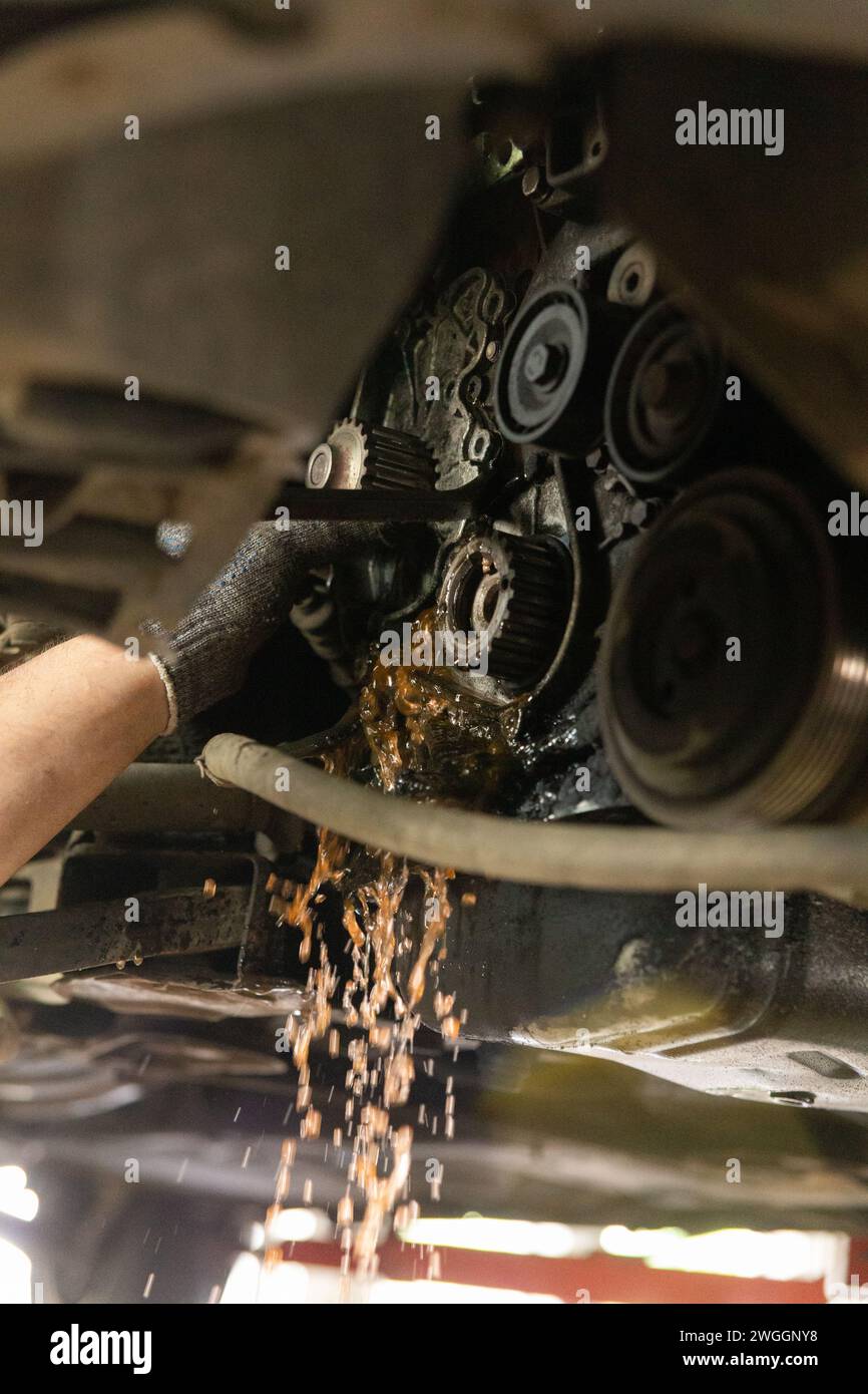 Remplacement de l'antigel dans le circuit de refroidissement du moteur. Vidange de l'ancien liquide de refroidissement lors de la dépose de la pompe à eau. Banque D'Images