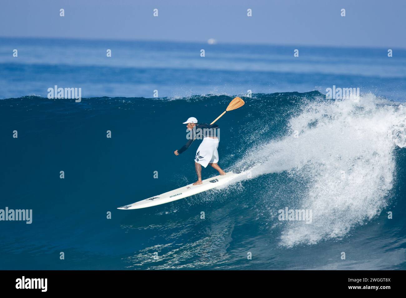 Un homme se tient debout sur le paddle surf à Pipeline sur la rive nord d'Oahu, 03.06.07 Banque D'Images