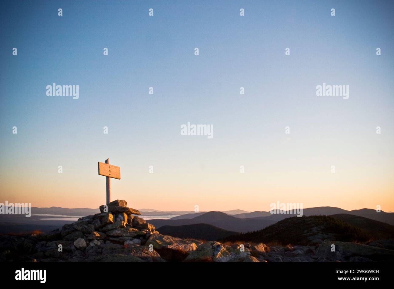 Le panneau du sommet du sentier des Appalaches sur Saddleback Mountain, dans le Maine, attrape les premiers rayons du soleil levant par un matin de septembre croustillant. Banque D'Images