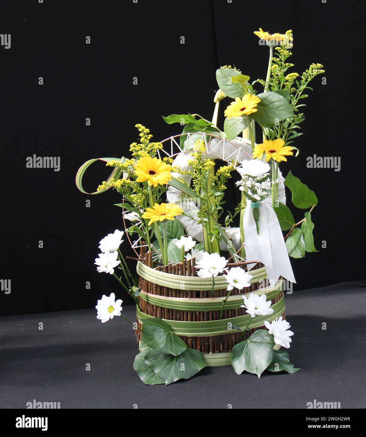 Un arrangement de fleurs d'été lumineux dans un panier en bois. Banque D'Images