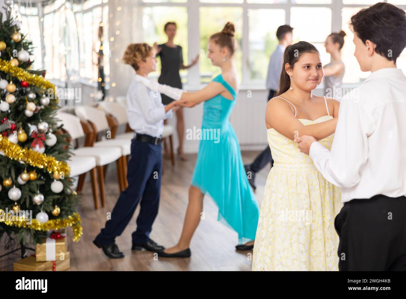 Adolescent garçon et fille dansant valse en couple pendant la leçon au studio dans l'atmosphère du nouvel an Banque D'Images