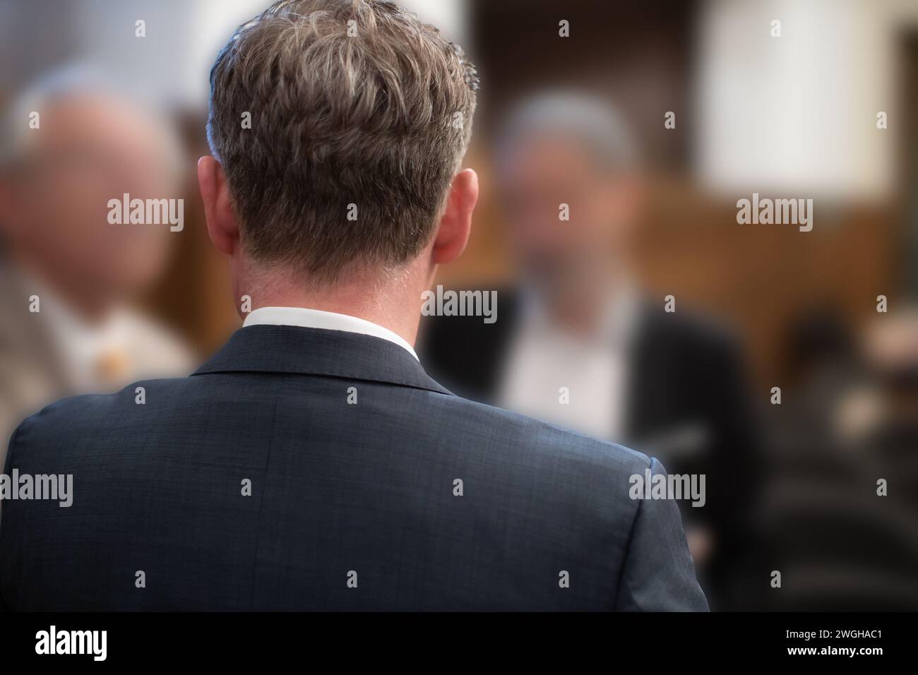 vue arrière d'hommes d'affaires méconnaissables ayant une discussion tout en se levant Banque D'Images