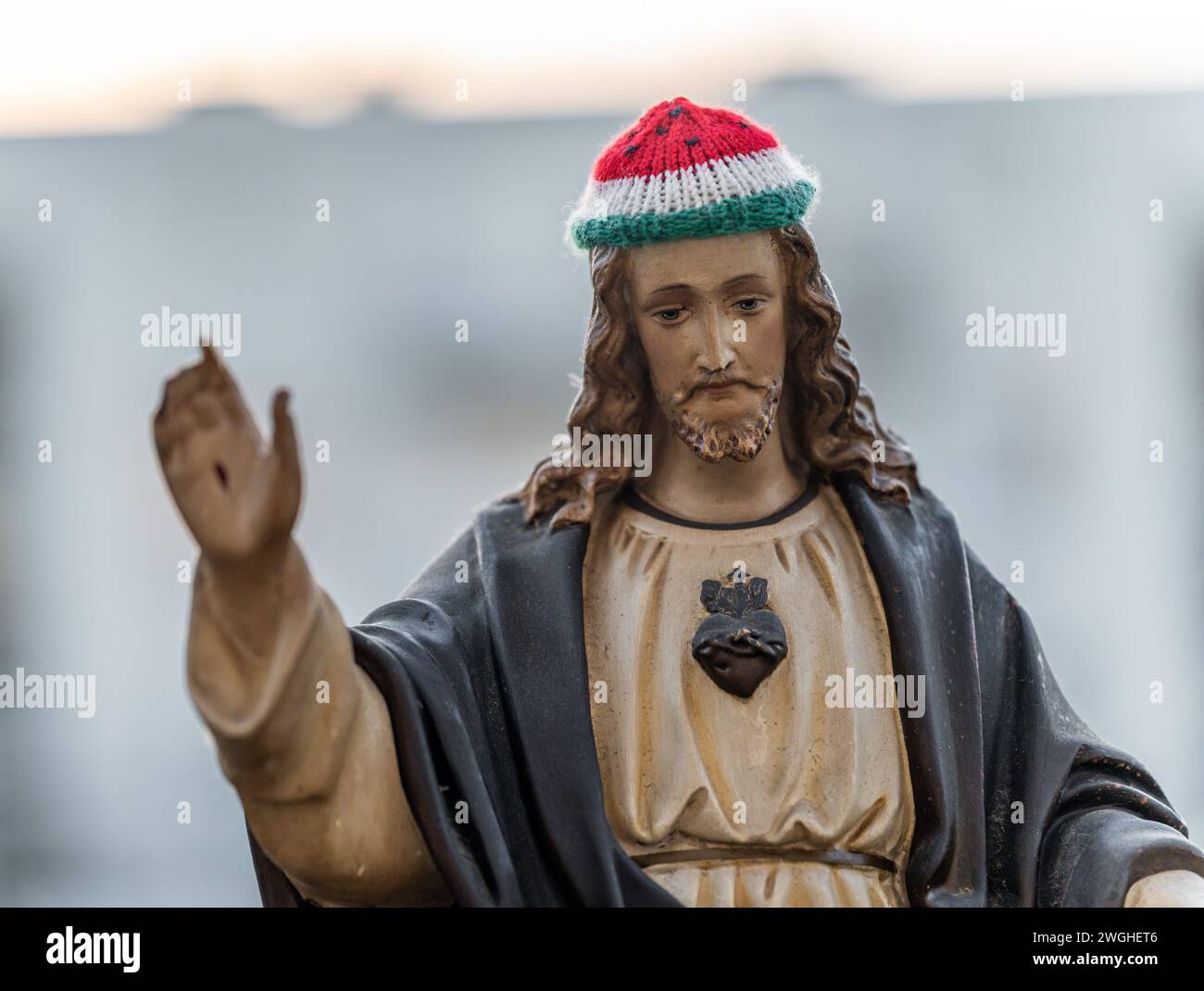 Statue de Jésus Christ portant un chapeau tricoté aux couleurs du drapeau palestinien Banque D'Images