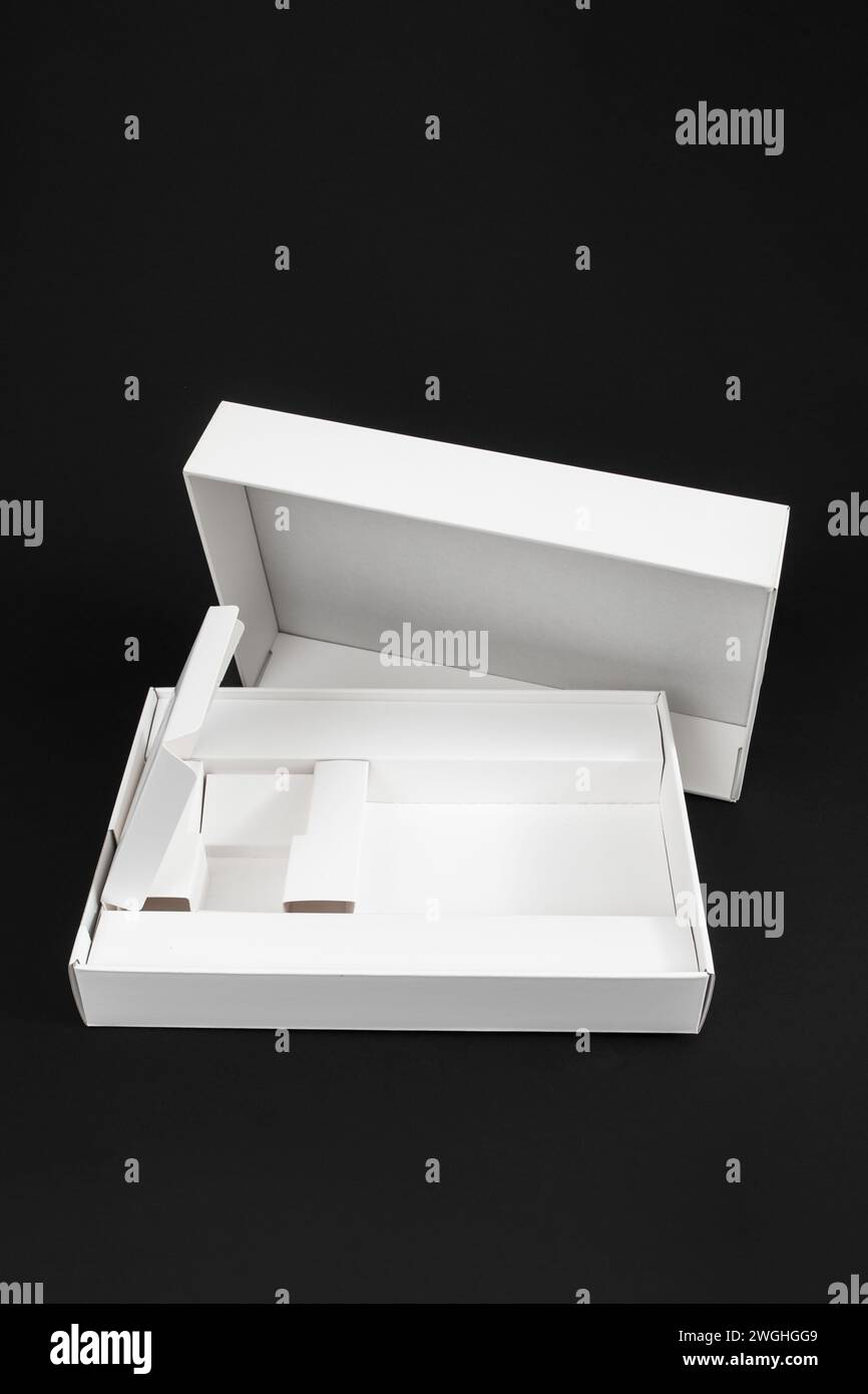 Boîte vide pour smartphone ou tablette, emballage en carton blanc isolé sur noir Banque D'Images
