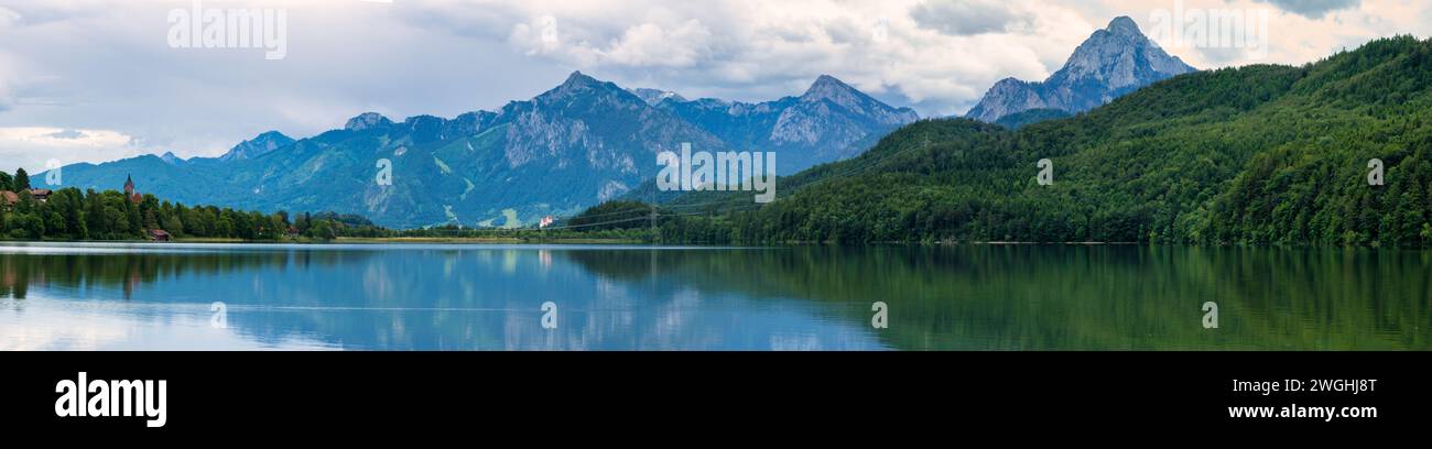 Scène tranquille : reflet de la chaîne de montagnes dans le lac entouré de verdure Banque D'Images