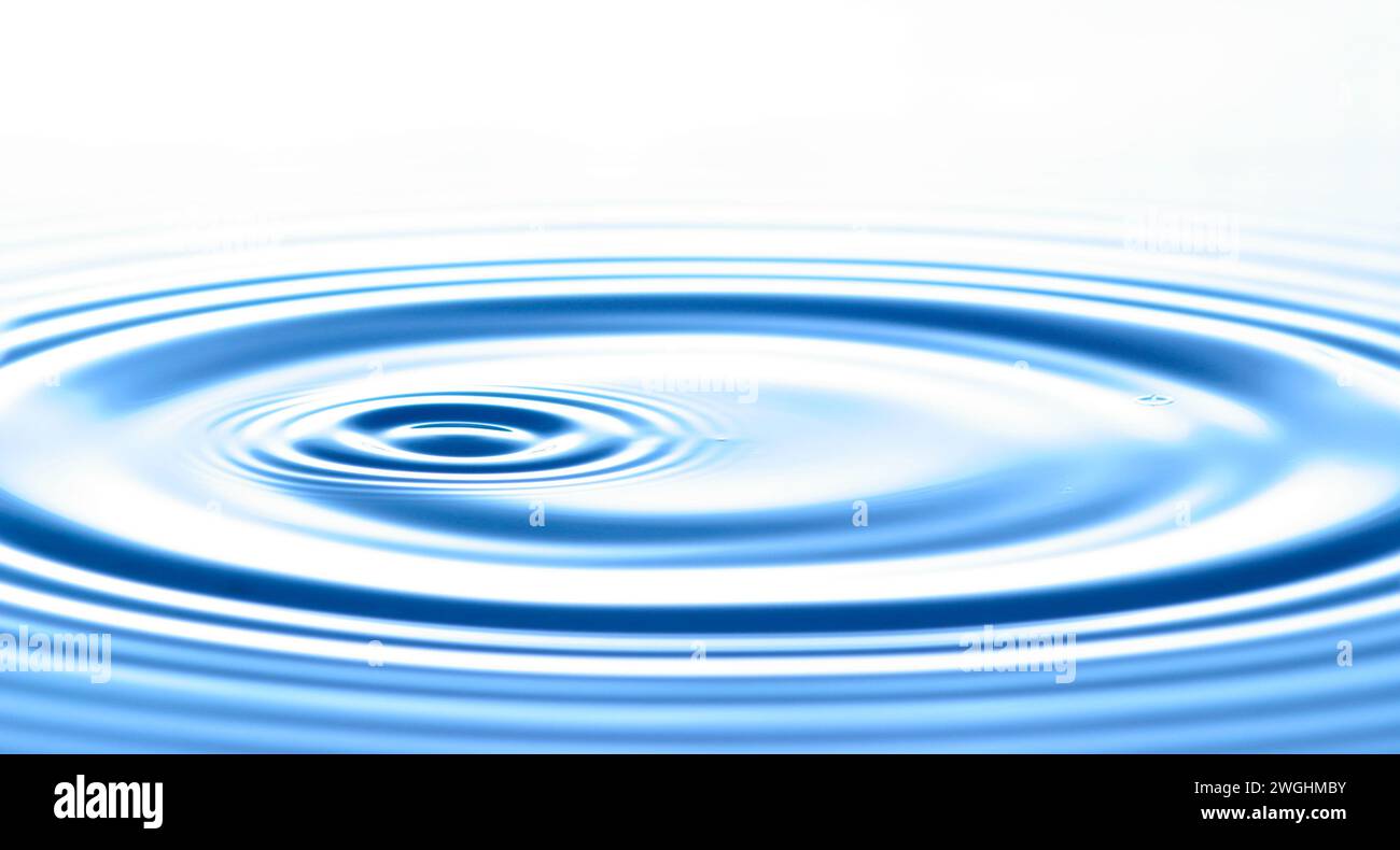 une goutte provoque des vagues circulaires à la surface de l'eau Banque D'Images