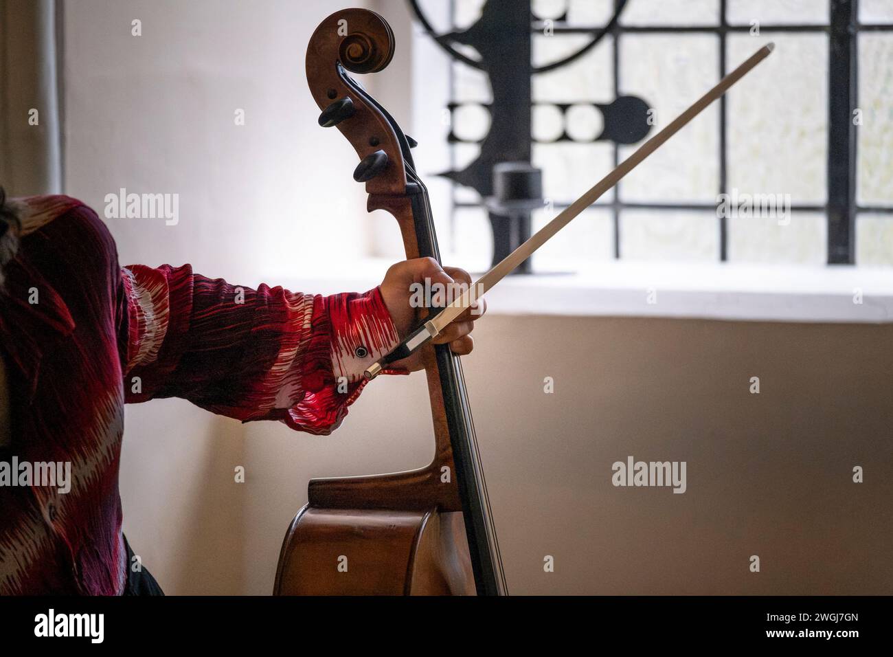 Un musicien tenant un violoncelle et un arc. Banque D'Images