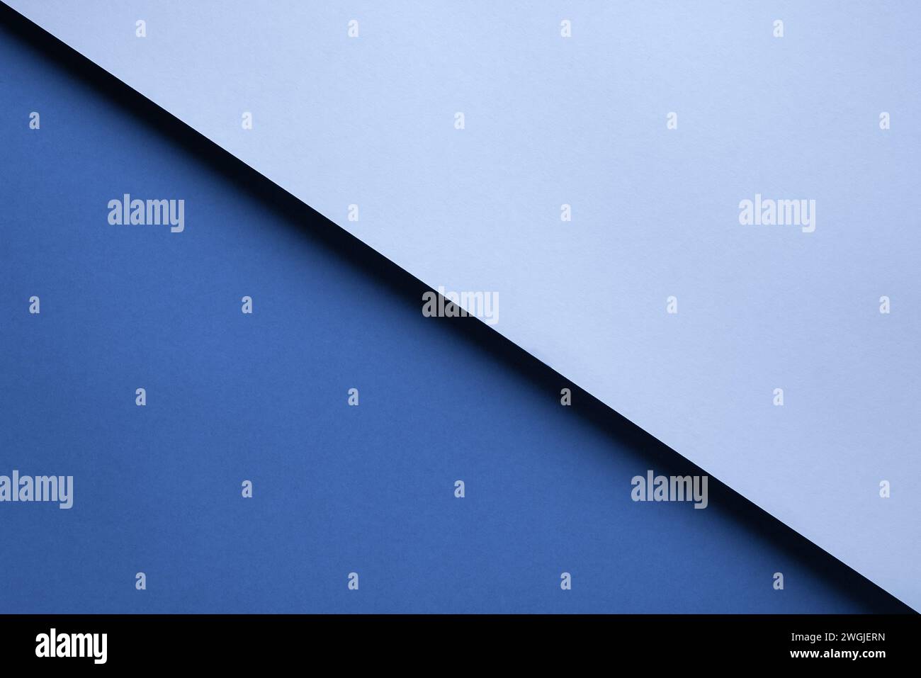Fond géométrique abstrait de deux morceaux de papier bleus superposés avec une ombre. Banque D'Images
