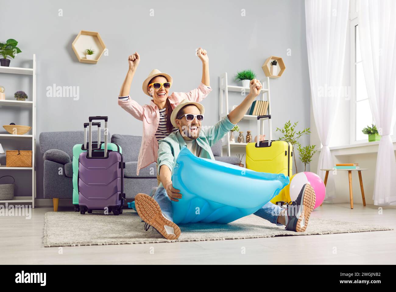 Couple excité drôle assis sur le matelas gonflable prêt pour le voyage de vacances. Banque D'Images