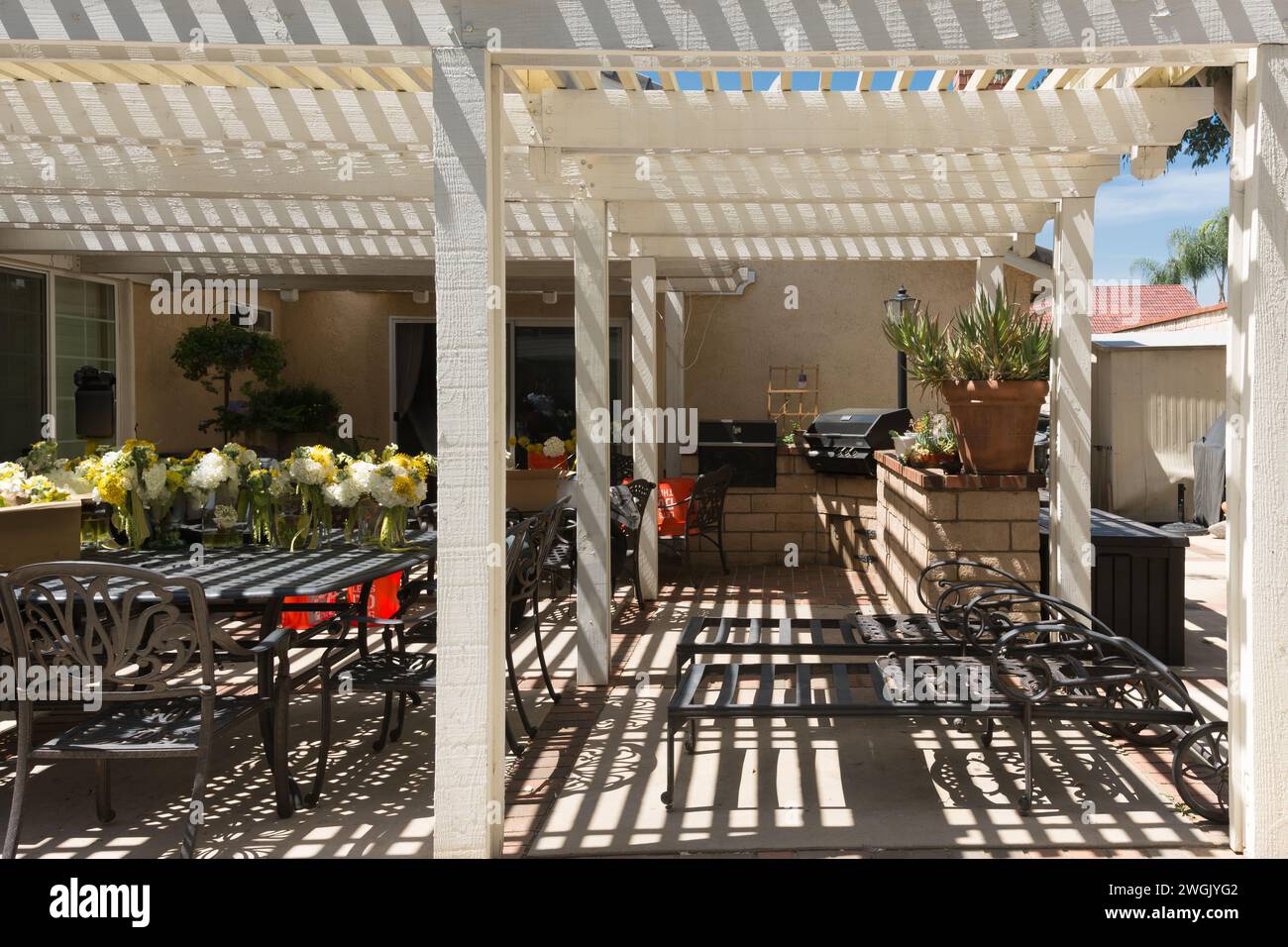 Une terrasse extérieure avec tables, chaises et barbecue Banque D'Images