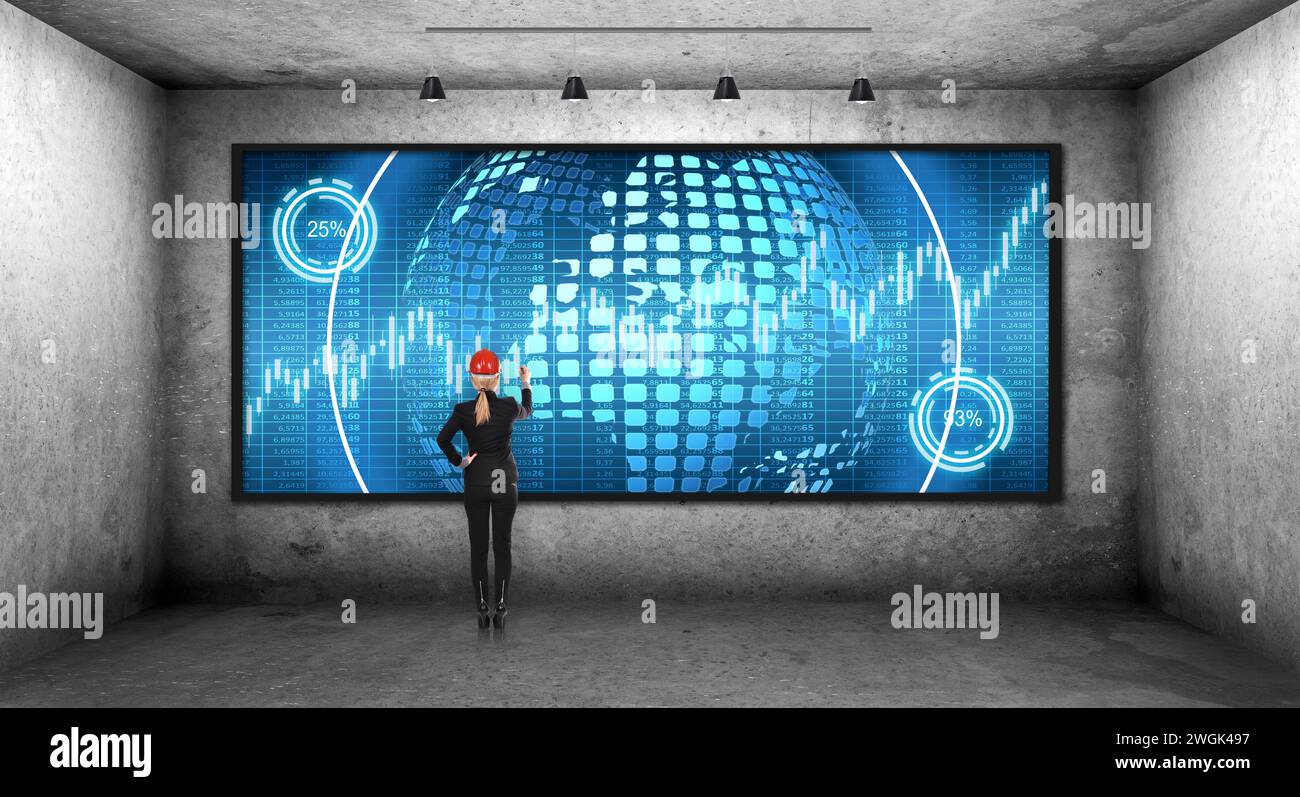 Femme d'affaires dans un casque dessine un hologramme d'affaires sur l'écran numérique. Chambre sombre en béton. Réalité virtuelle et concept de réseau mondial. Banque D'Images