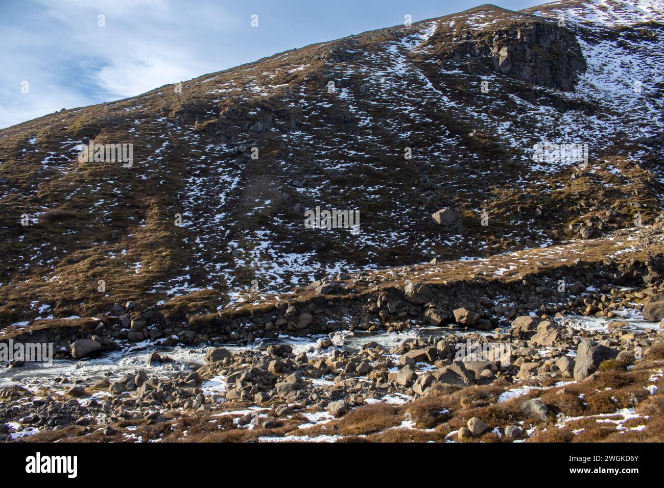 Montagne avec des taches de neige en automne. Beaucoup de pierres et de rochers. Ciel bleu avec des nuages blancs. Rjukandafoss, Nord-est de l'Islande. Banque D'Images