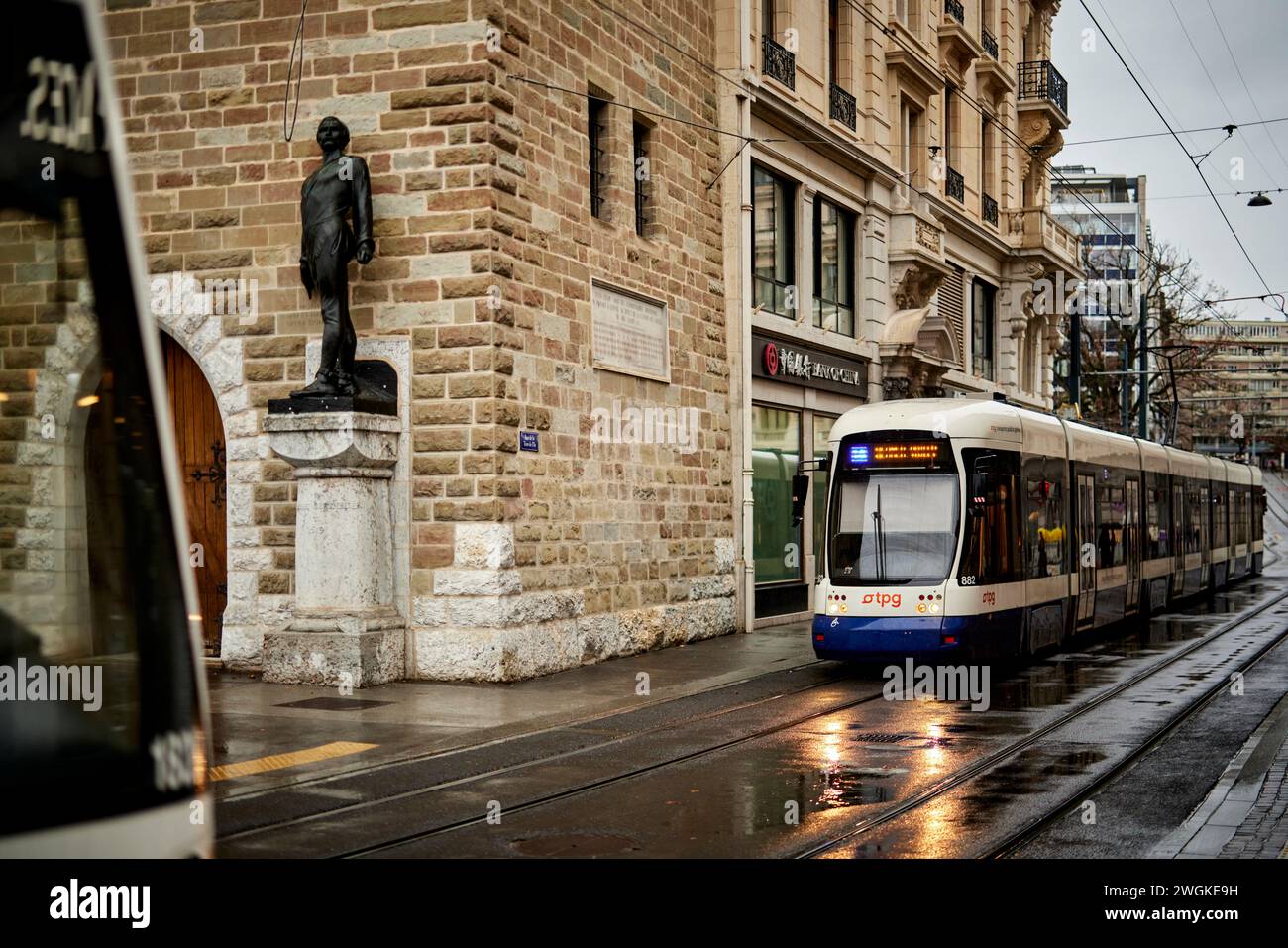 Genève ville en Suisse Berthelier Statue partie et ancienne tour du château avec passage Transports publics Genevois TPG Banque D'Images