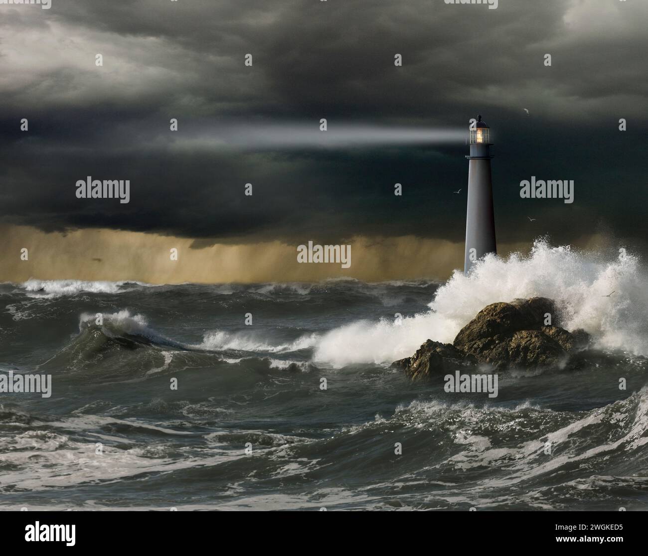 Un phare projette son faisceau de lumière guidant sur des mers agitées sous un ciel orageux dans une image sur la sécurité, l'adversité et la sécurité. Banque D'Images