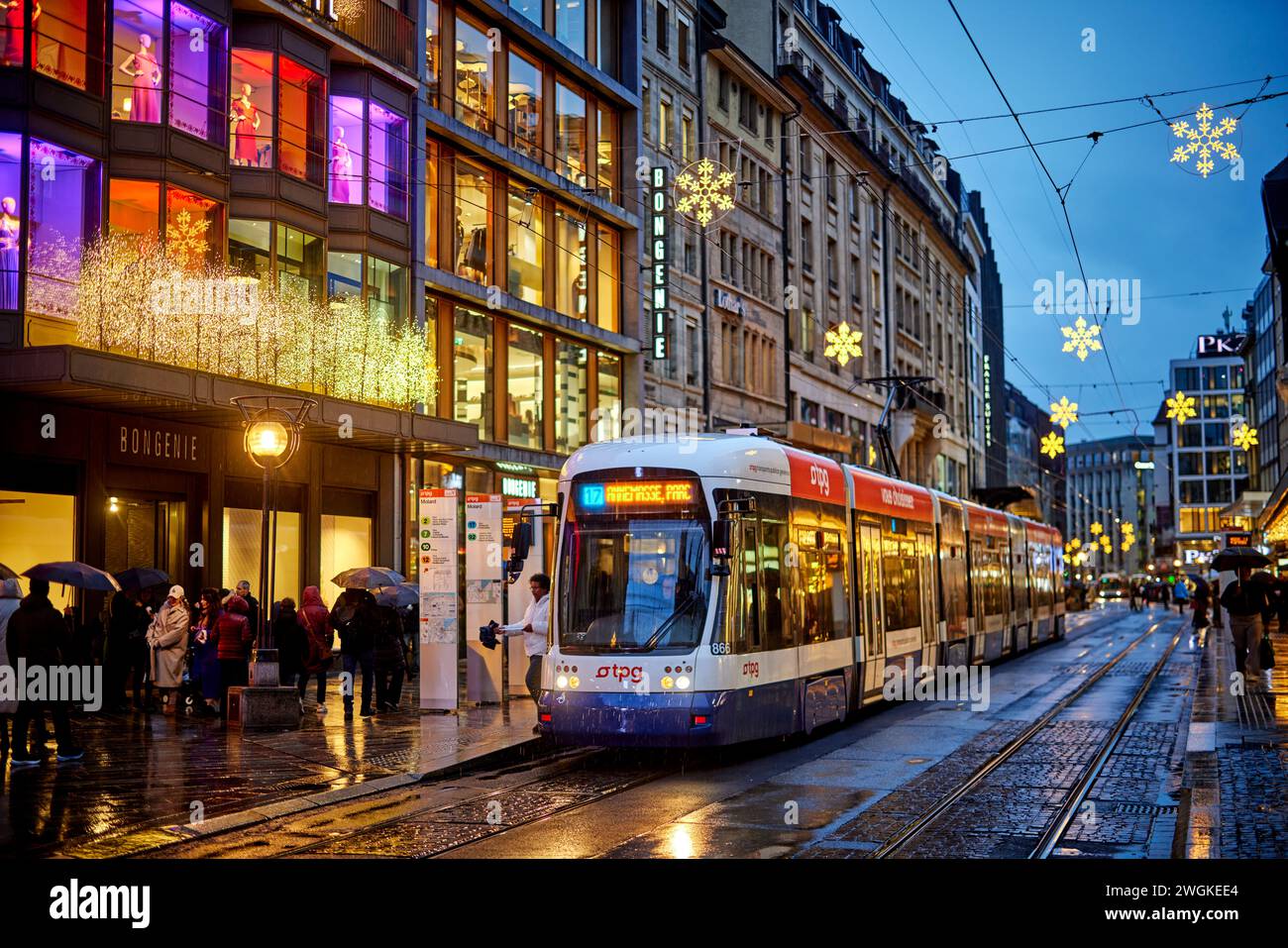 Genève ville en Suisse Rue de Rive shopping sous la pluie et Transports publics Genevois TPG Banque D'Images