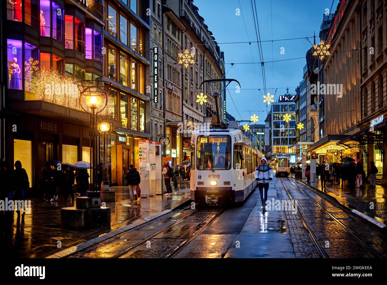 Genève ville en Suisse Rue de Rive shopping sous la pluie et Transports publics Genevois TPG Banque D'Images