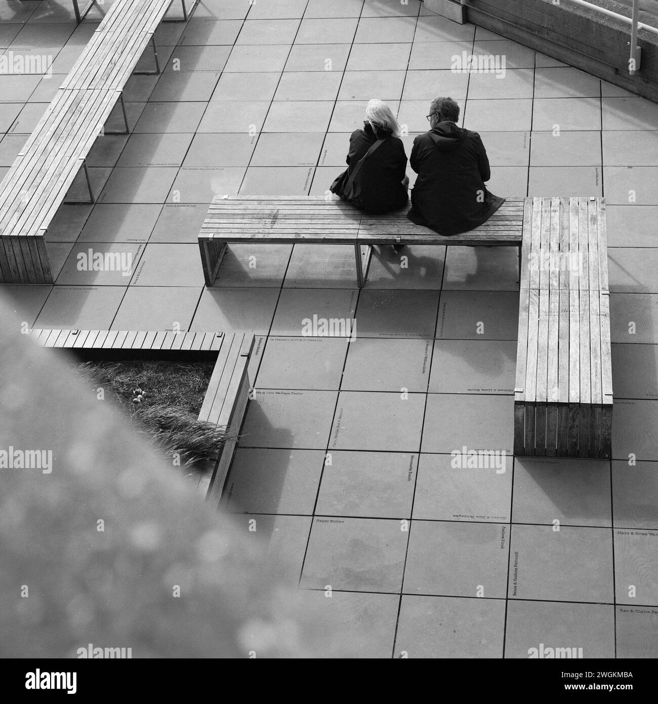 Couple marié assis sur un banc devant le National Theatre, South Bank, Londres Banque D'Images