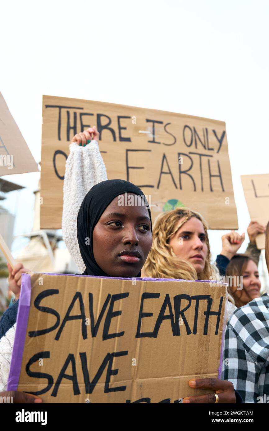Focus sur la femme sérieuse africaine avec des militants lors de manifestations contre les usines de pollution. Banque D'Images
