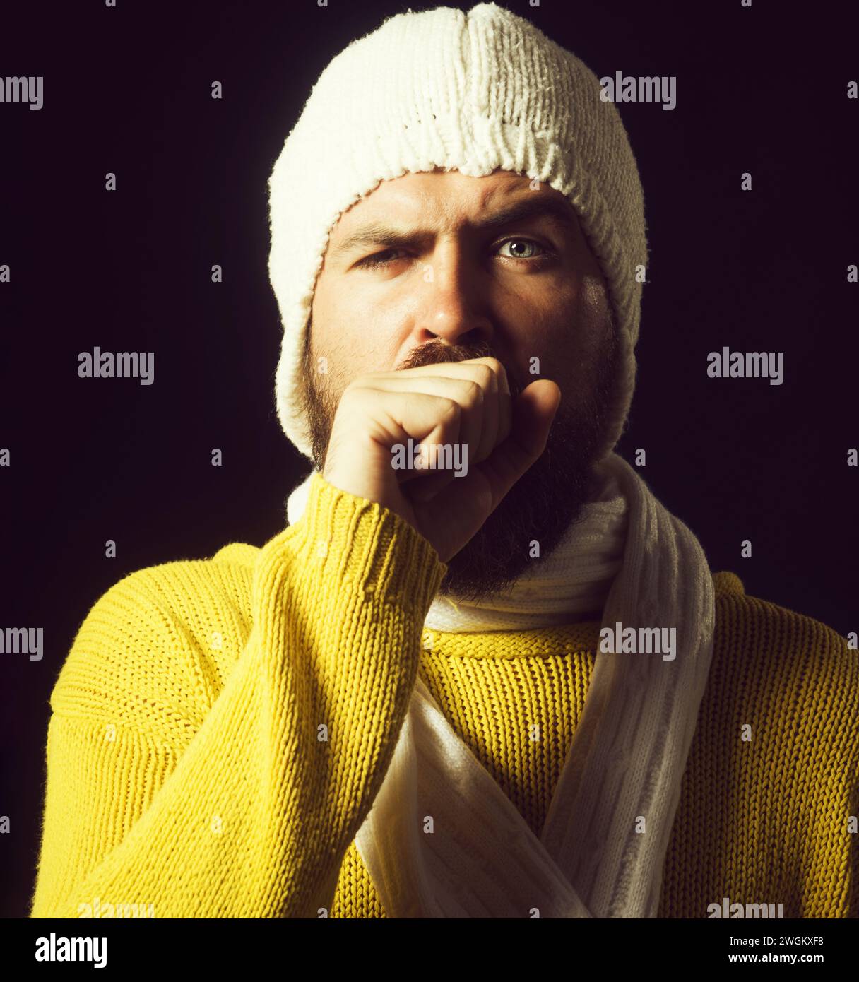 Homme malsain atteint de grippe ou de pneumonie toussant dans le poing. Les hommes malades ont la toux comme symptôme de la grippe, du rhume ou de la bronchite. Homme malade en pull et chapeau Banque D'Images