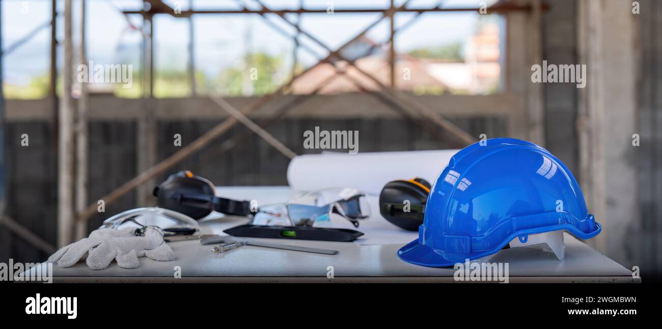 Conception de modèle d'architecture d'outil d'ingénieur et casque de sécurité HardHat sur la table de réunion avec le projet de papier d'entrepreneurs avec l'ingénieur et l'architecte Banque D'Images