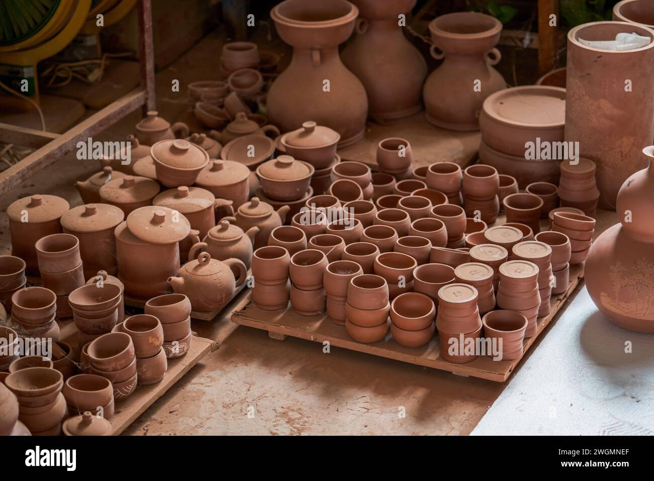 Embryons d'argile soigneusement empilés et moules dans une usine de poterie chinoise traditionnelle Banque D'Images