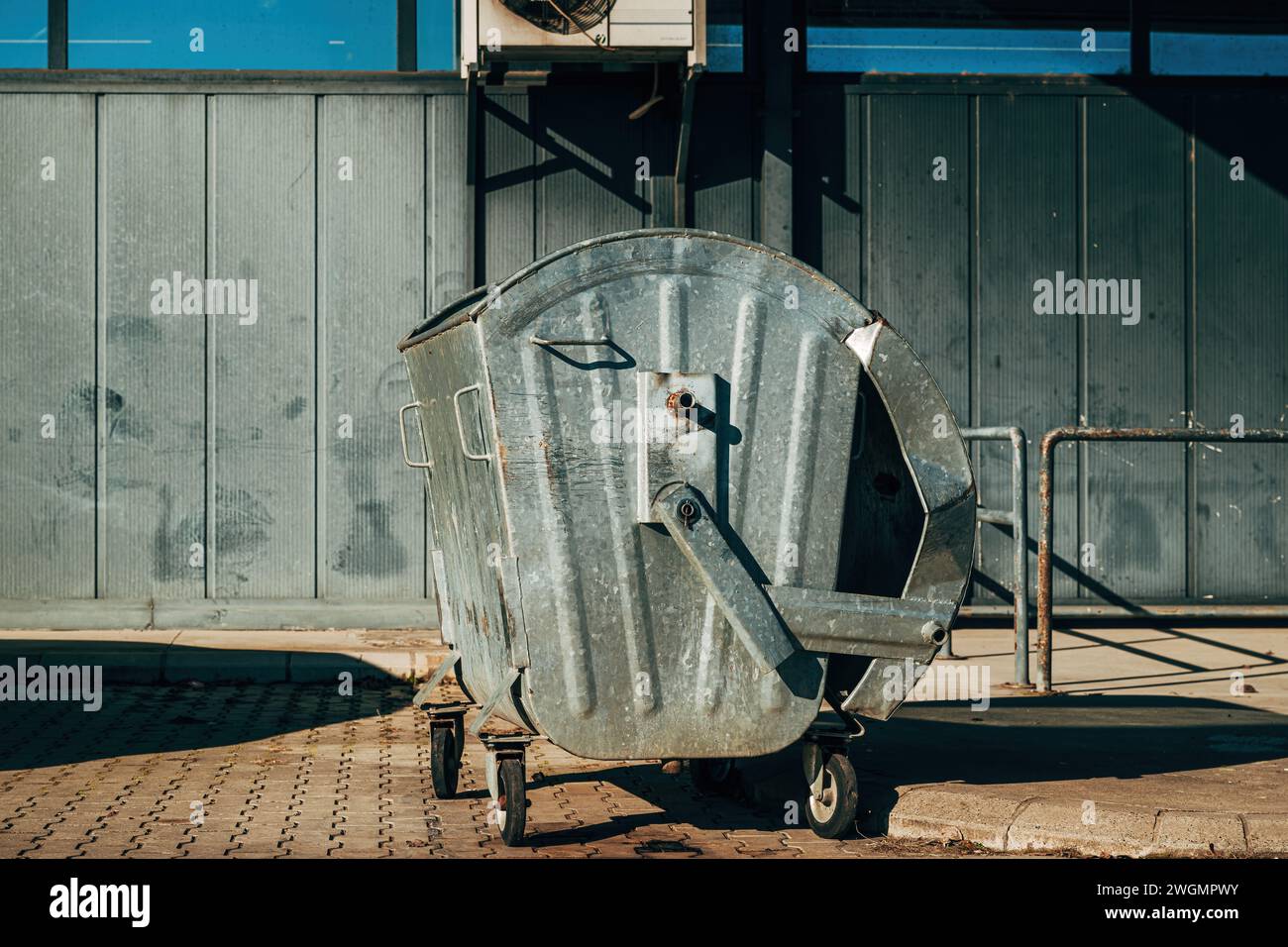 Conteneur à déchets métallique devant le bâtiment industriel, mise au point sélective Banque D'Images