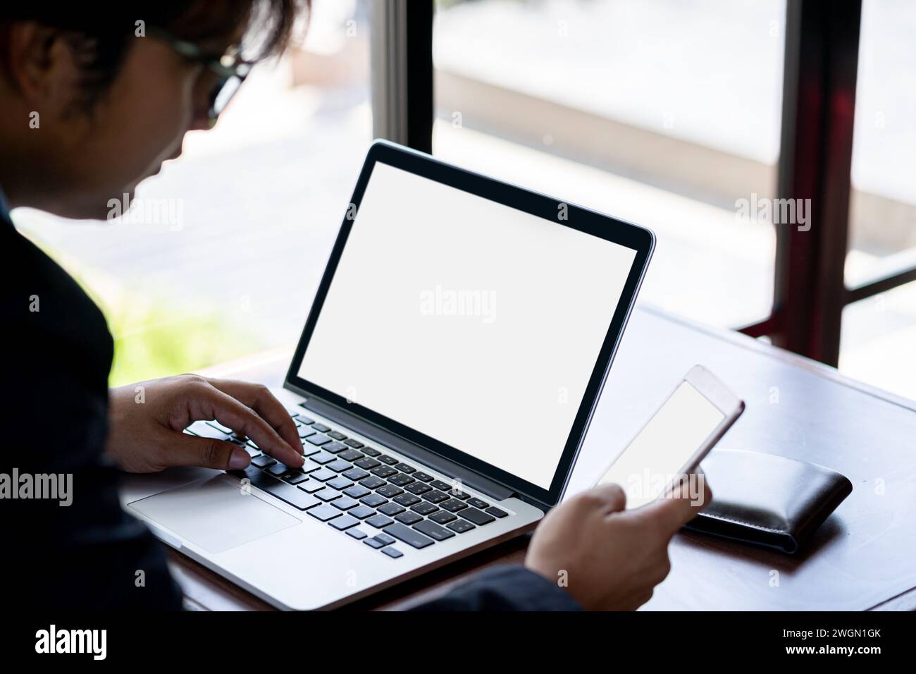 Homme d'affaires utilisant smartphone pour partager Internet pour ordinateur portable pour travailler dans le café. Freelance travaillant dans un café Banque D'Images