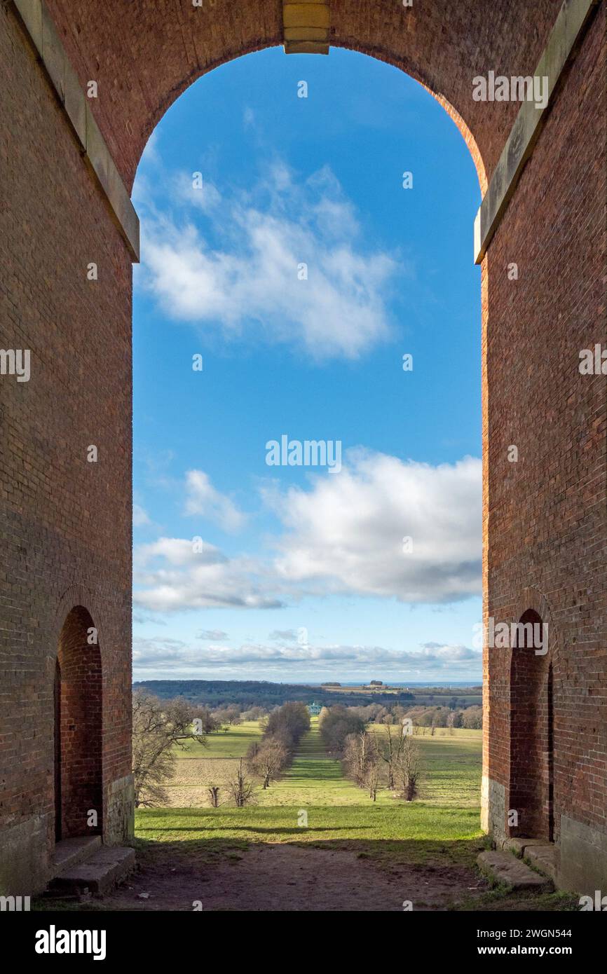 Vue à travers l'arche unique de Bellmount Tower sur l'avenue bordée d'arbres jusqu'à Belton House, Grantham, Lincolnshire, Angleterre, Royaume-Uni Banque D'Images