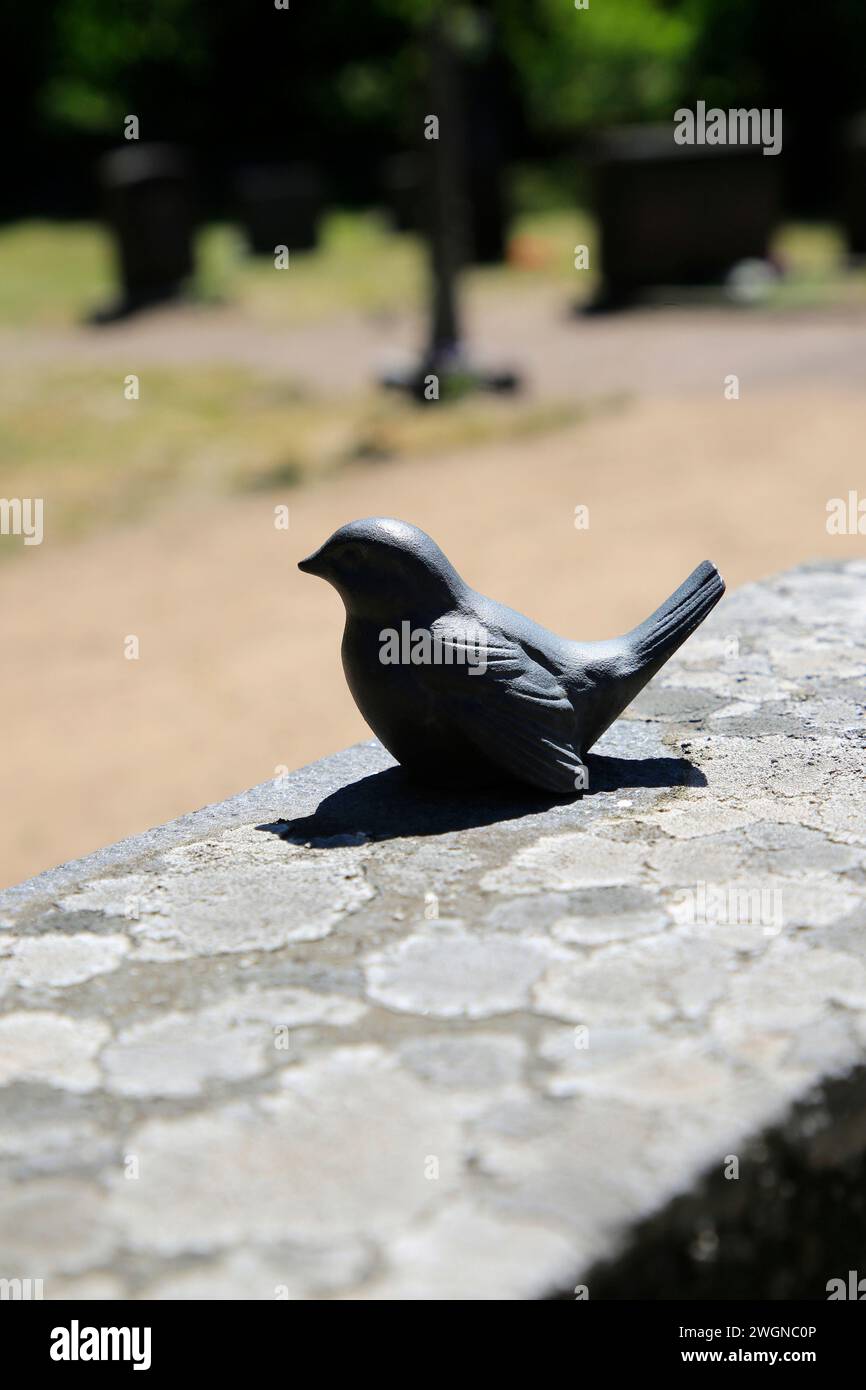 Petit oiseau noir de pierre sur pierre tombale dans le vieux cimetière. Banque D'Images Petit oiseau noir de pierre sur pierre tombale dans le vieux cimetière. Banque D'Images