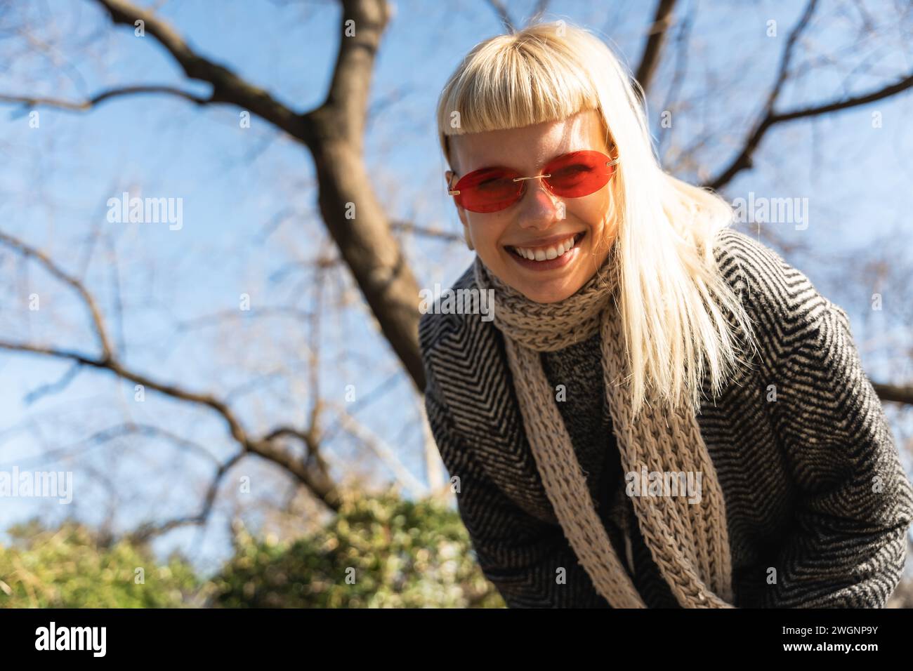 Jeune fille hippie amusante heureuse montrant la langue à la caméra pour le plaisir et faire des visages drôles tout en portant des lunettes de soleil fraîches. Femme féminine attrayante appréciant Banque D'Images