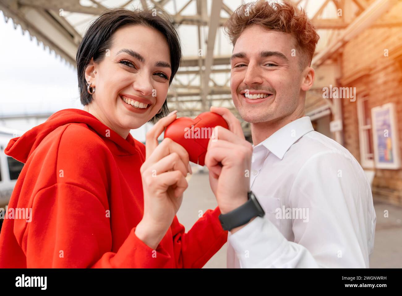 Couple heureux essayant de connecter deux morceaux de cœur - relation, dans le concept d'amour Banque D'Images