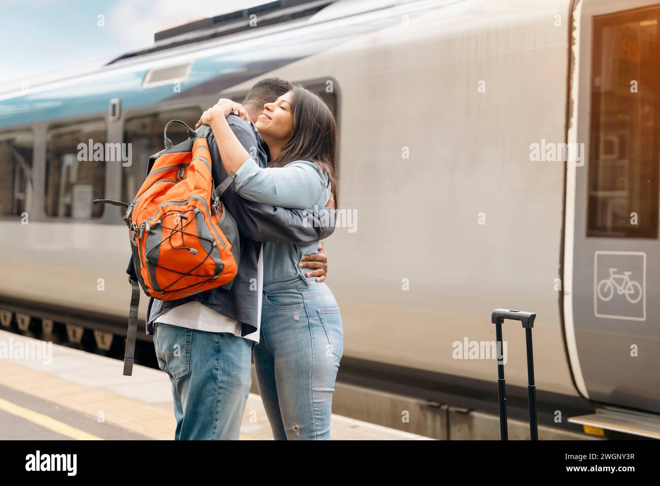 un jeune beau couple embrasse sur la réunion de plate-forme, disant au revoir le conjoint, ami. Concept de style de vie de voyage Banque D'Images