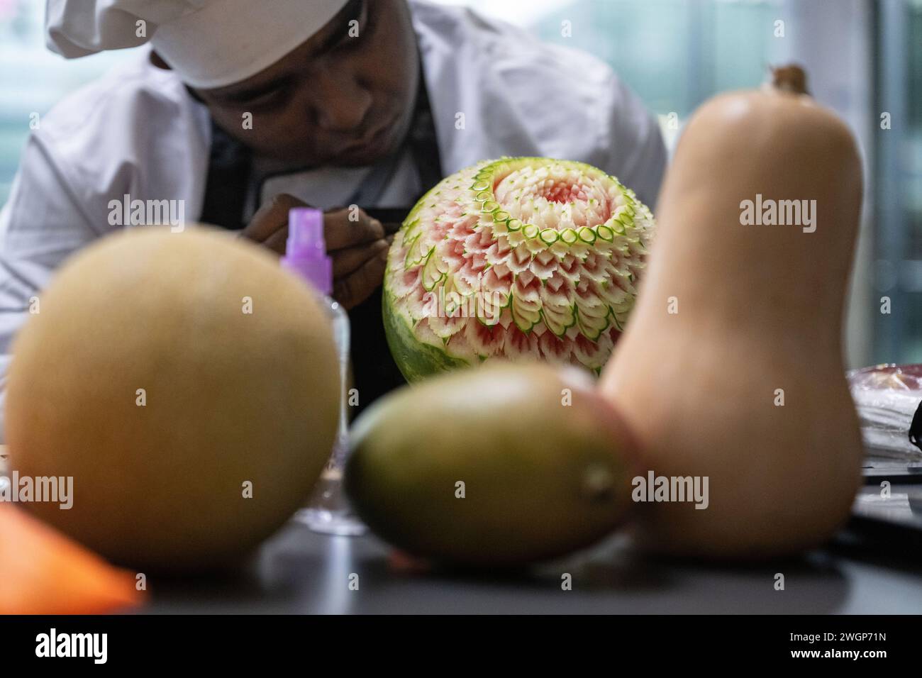 Stuttgart, Allemagne. 06th Feb, 2024. Un participant à un concours de sculpture de fruits et légumes, la sculpture artistique de fruits et légumes dans le cadre des 'IKA / Jeux Olympiques culinaires', sculpte son entrée au concours. Les Jeux Olympiques culinaires rassemblent des chefs internationaux pour ce que les organisateurs prétendent être la plus grande et la plus ancienne compétition de cuisine au monde. Crédit : Marijan Murat/dpa/Alamy Live News Banque D'Images